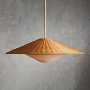 Close-up detail of handwoven rattan pendant lamp showing textured weave pattern and gold metal hanging rod against concrete wall background