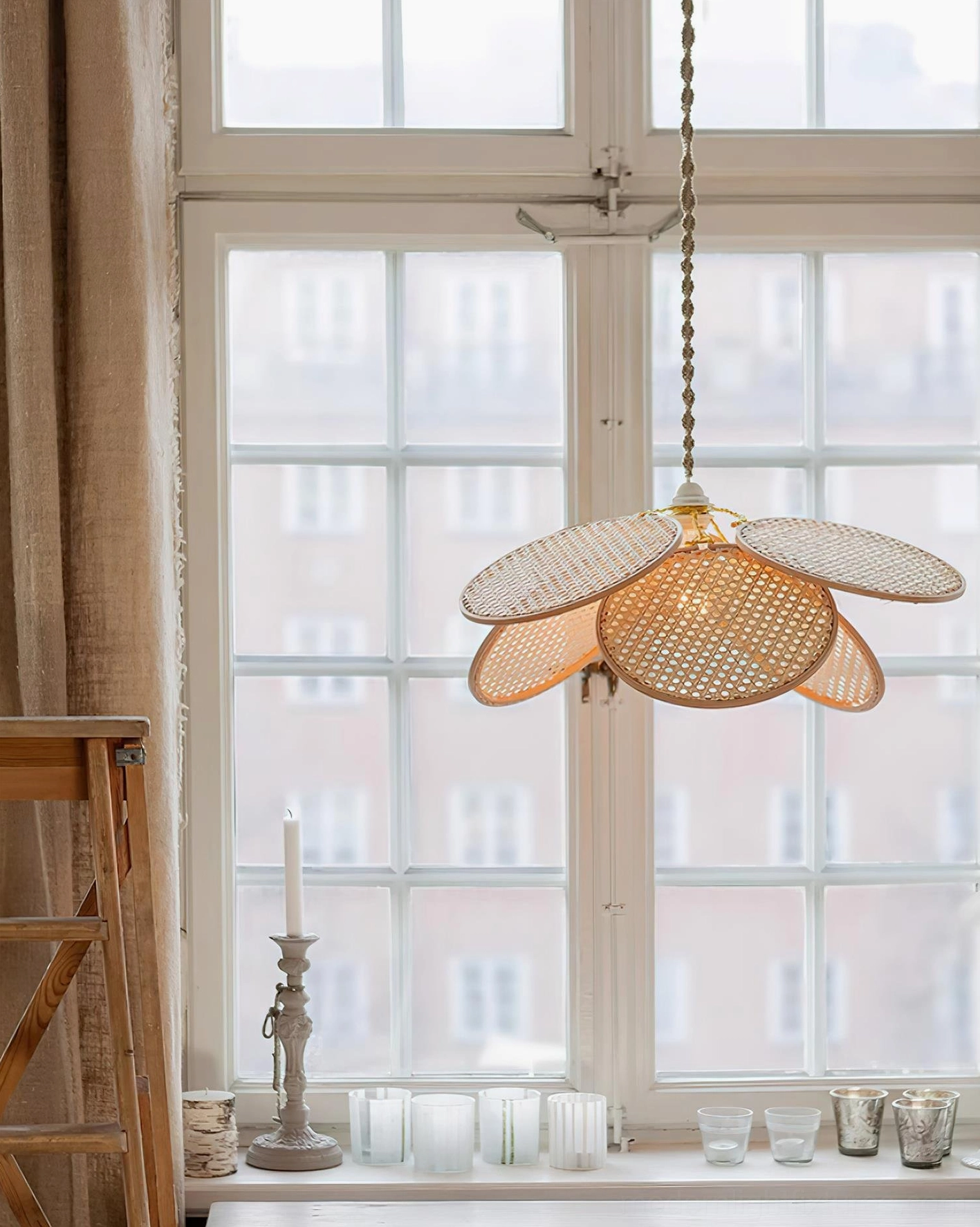 Handwoven rattan petal pendant fixture displayed in cozy residential room showing warm natural lighting ambiance