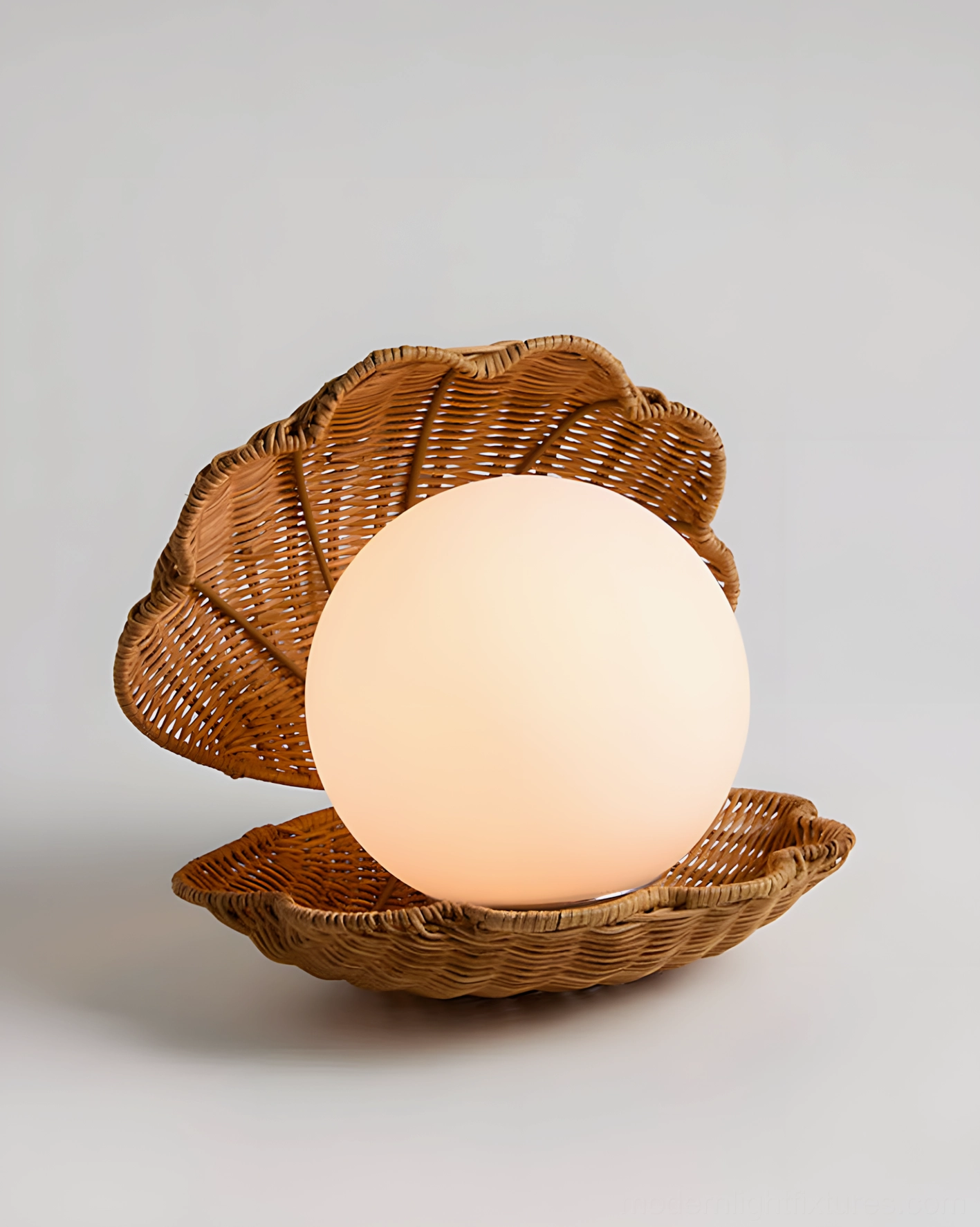 Illuminated frosted glass globe rattan seashell table lamp close-up studio shot