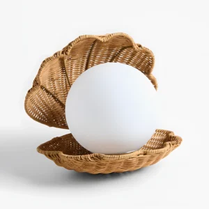 Hand-woven rattan shell table lamp three-quarter angle displaying natural texture and frosted light