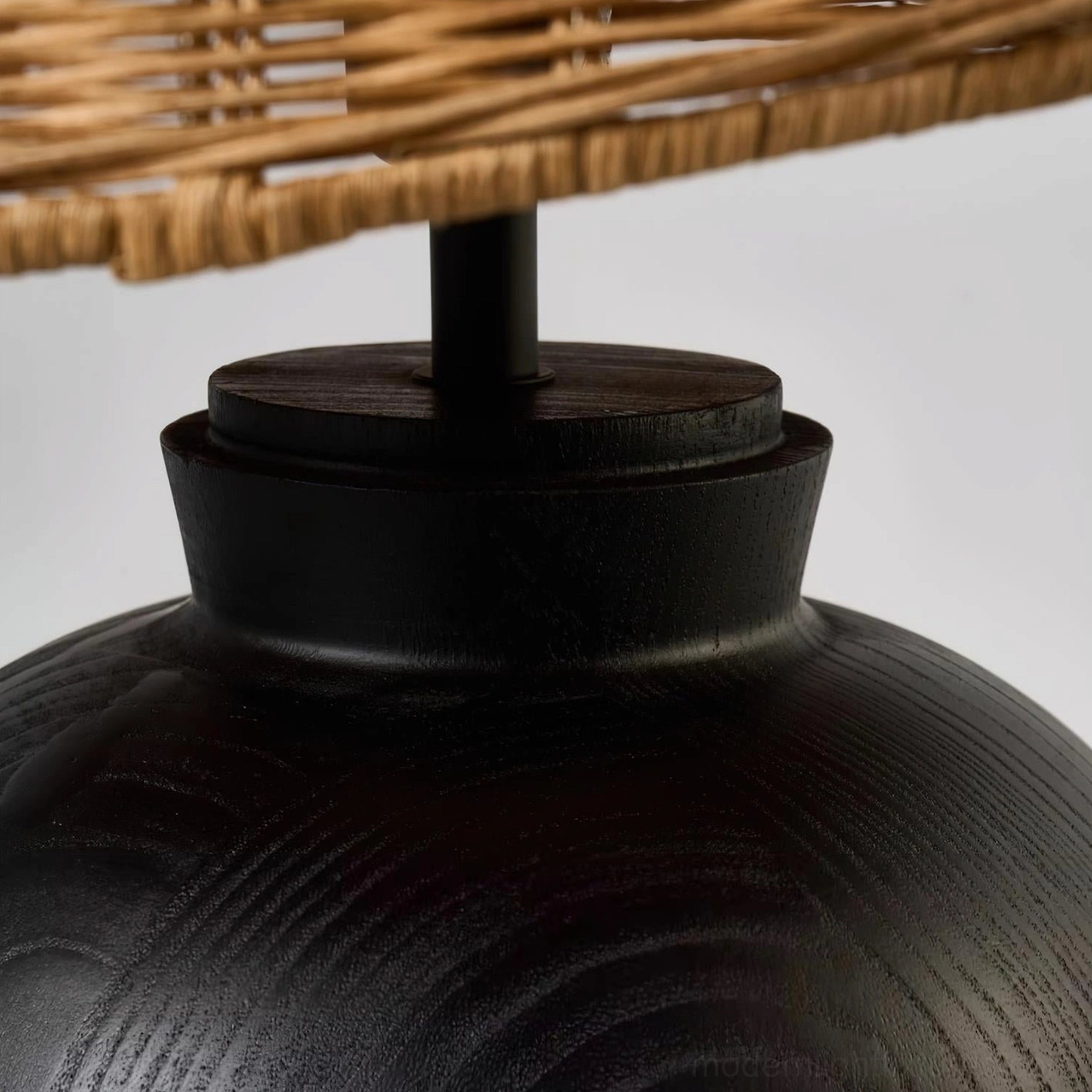Contemporary rattan table lamp creating warm ambient lighting in bedroom or living room space