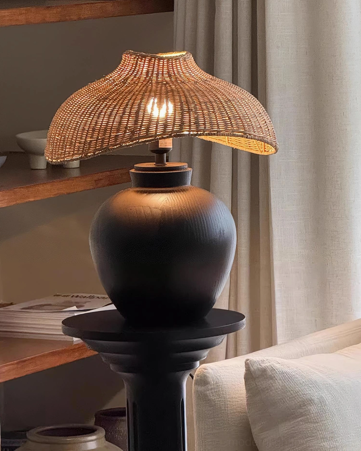 Rattan table lamp base detail showing matte black finish and wood construction, sculptural design element