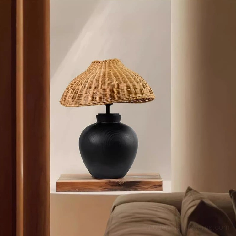 Modern rattan table lamp displayed on living room recessed shelf, showing natural rattan weave and black wooden base