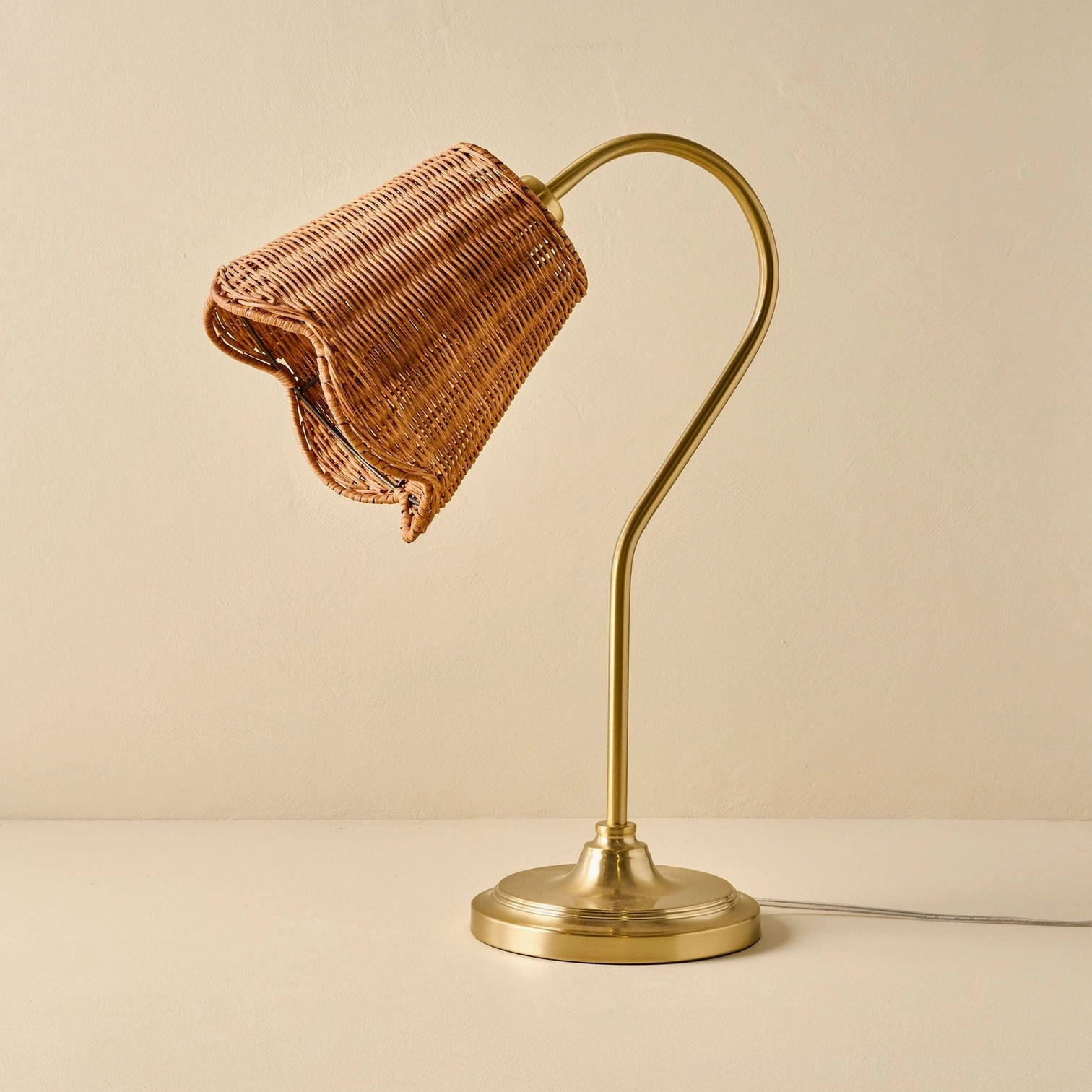 Hand-woven rattan table lamp front flat view with visible gold metal base and power cord