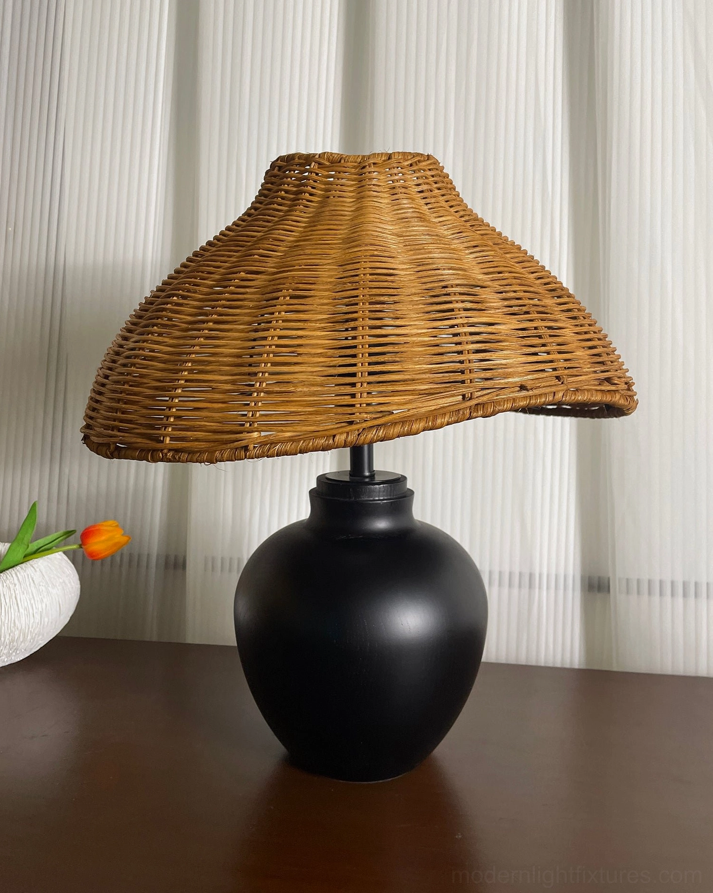 Hand-woven rattan shade table lamp providing soft filtered light for bedroom or living room accent