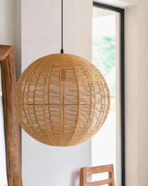 Modern boho rattan hanging lamp installed in contemporary dining area with natural light