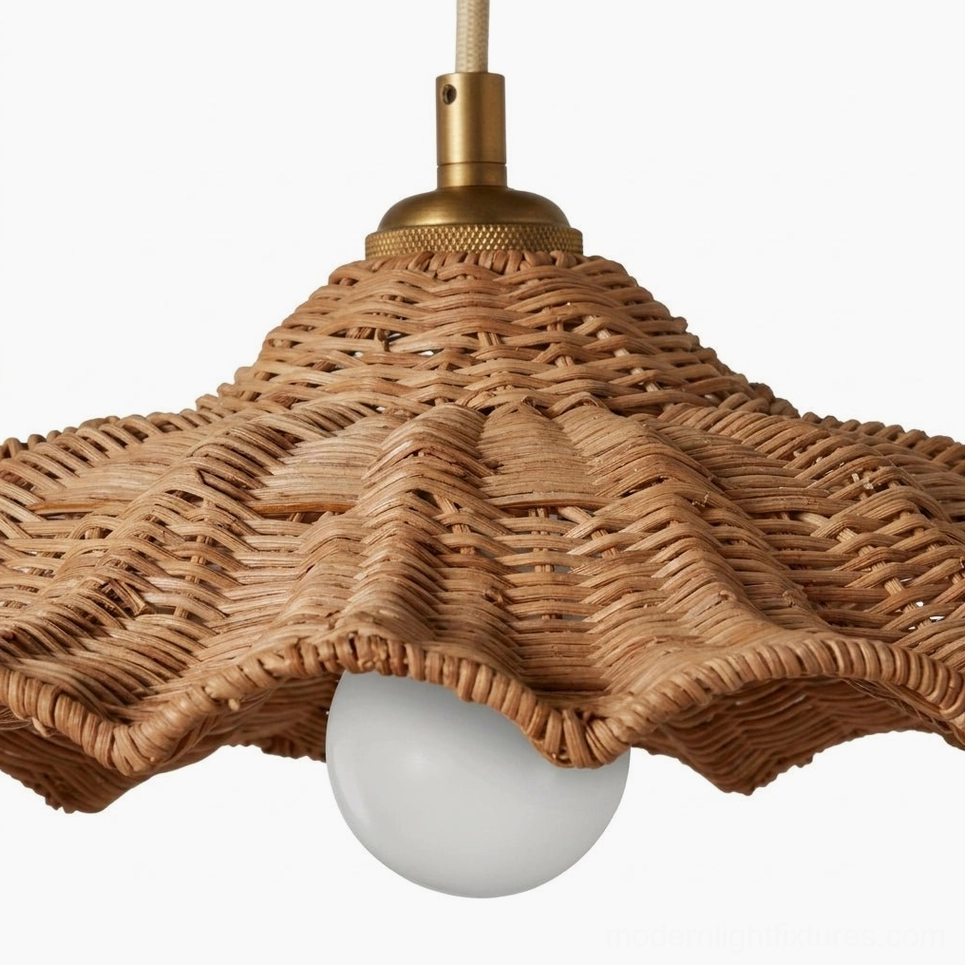 Low-angle close-up of Ravela handwoven rattan pendant showing scalloped rim detail, brass hardware, and LED bulb with coastal bohemian aesthetic