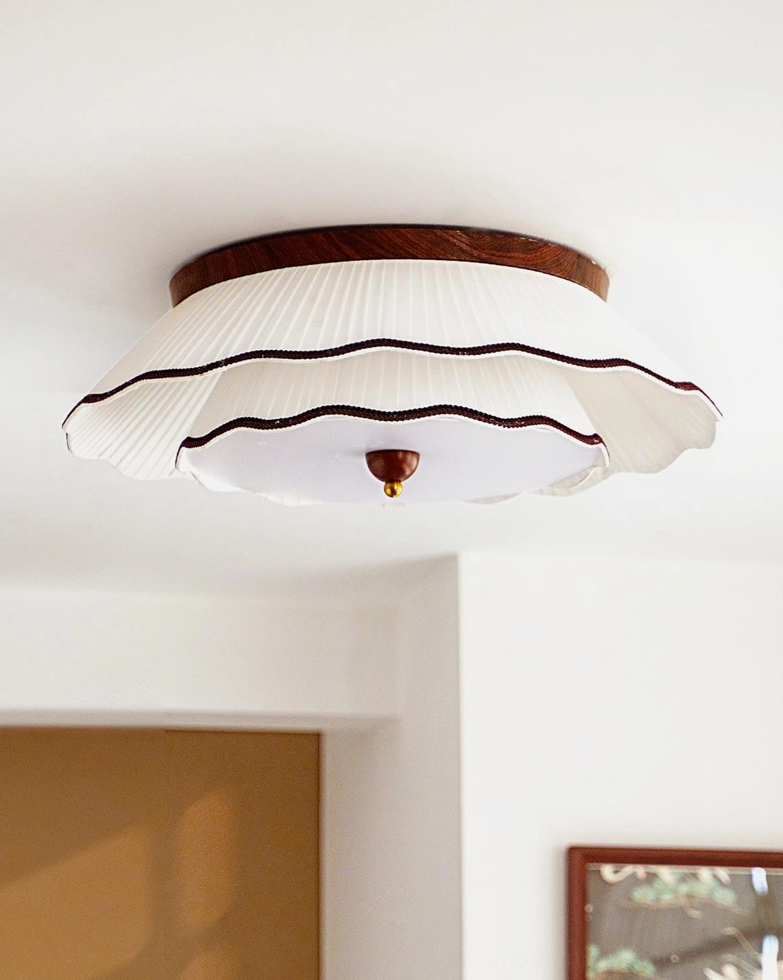 Scalloped ruffled pleated ceiling lamp with walnut wood base and decorative brass finial overhead view