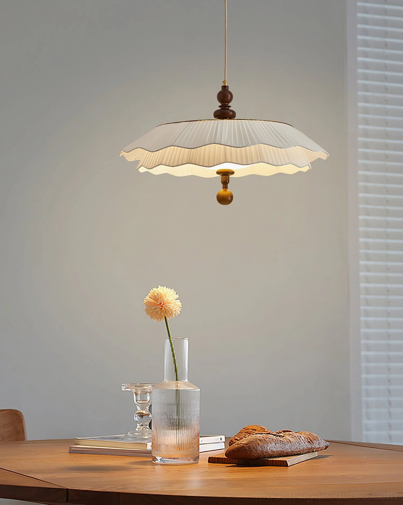 Ravina scalloped pendant lamp three-quarter hanging view with warm ambient glow over dining table