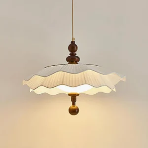 Ravina vintage pleated pendant lamp hanging with soft warm glow, three-quarter view showing pleated fabric design
