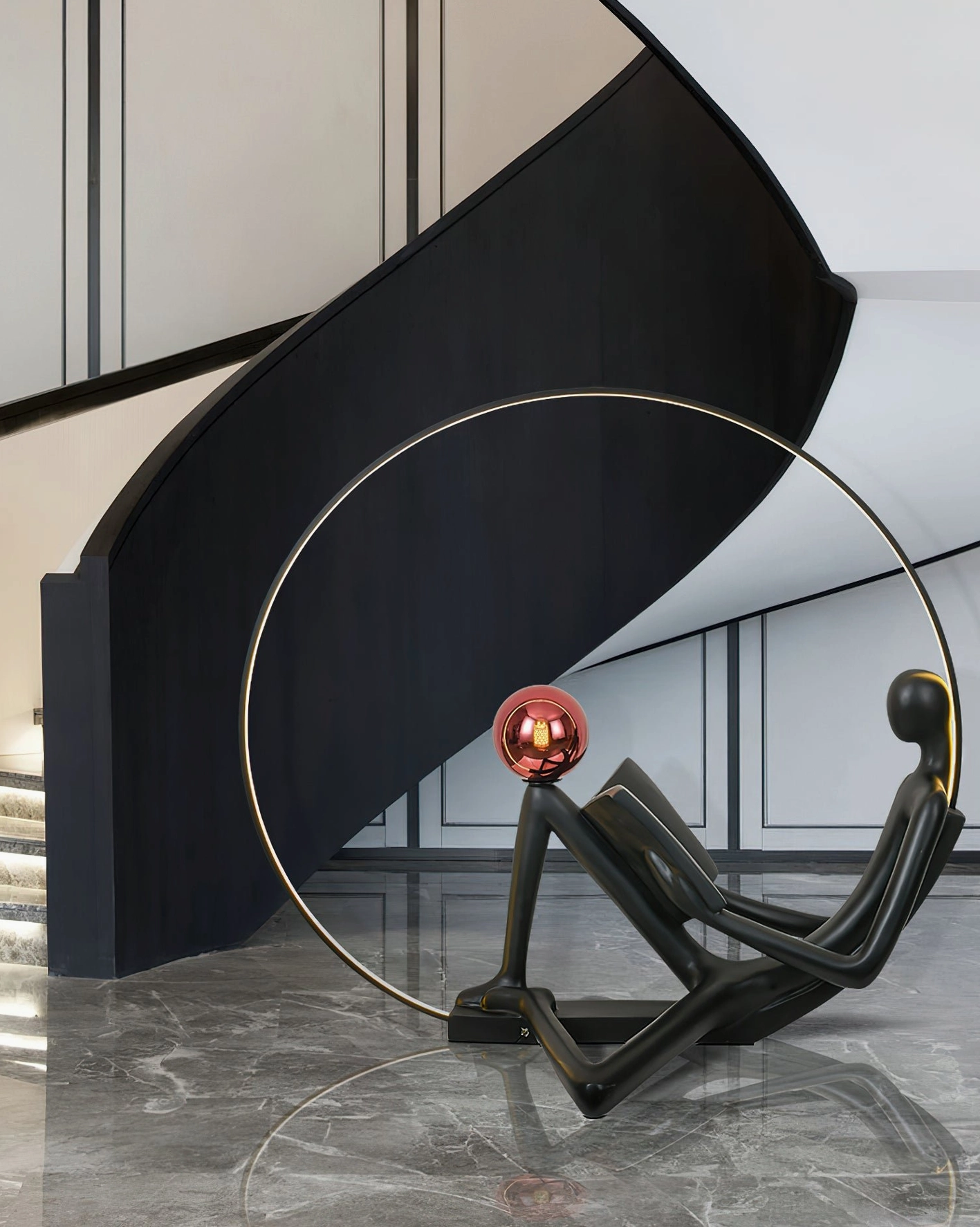 Black sculptural reading floor lamp with red globe, modern luxury stairwell with dark marble flooring and curved staircase