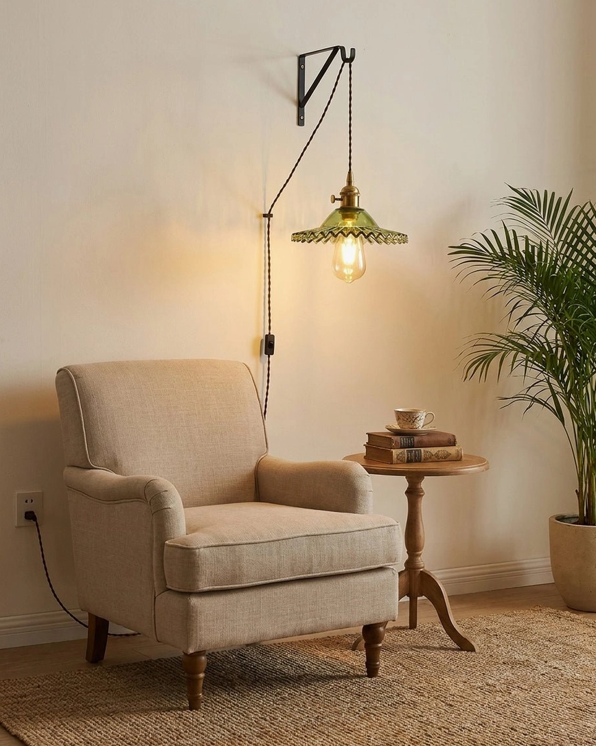 Reading corner plug-in pendant light with green fluted glass and brass accents, eye-level view with armchair