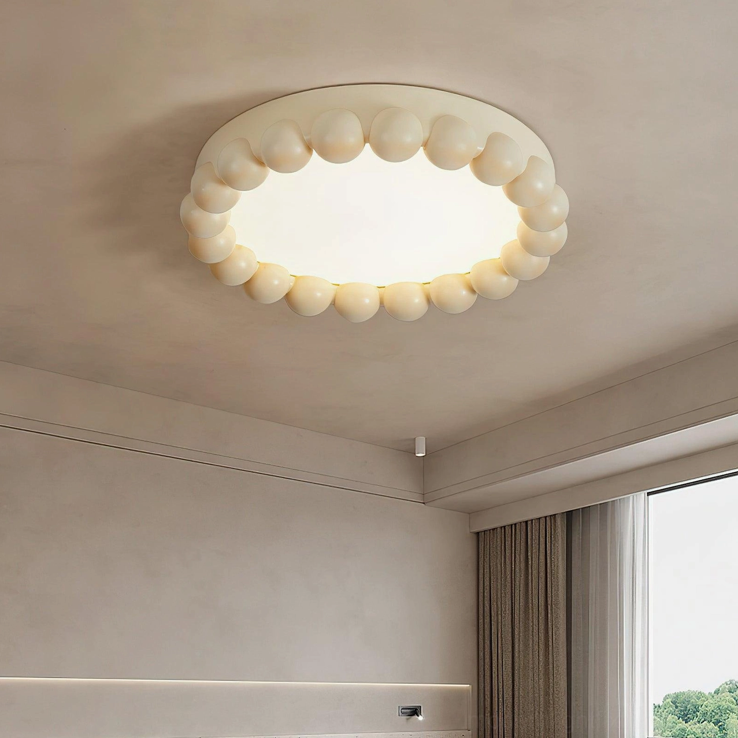 Overhead view of beaded recessed ceiling light in cream finish mounted in bright bedroom with large windows