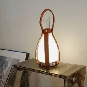 Cordless portable LED table lamp with warm 3000K ambient light on contemporary acrylic furniture, three-quarter view showcasing frosted glass shade and rechargeable design
