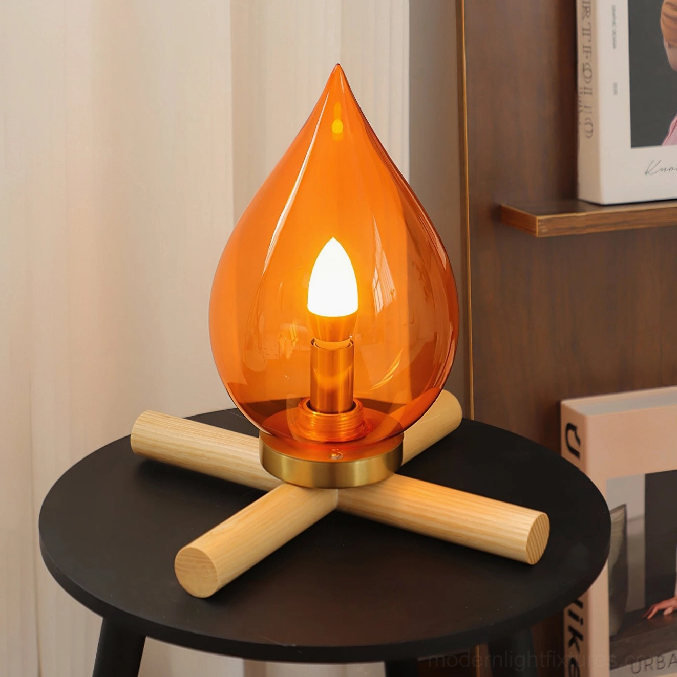 Portable rechargeable table lamp in wood color, lit warm glow on living room end table with bookshelf