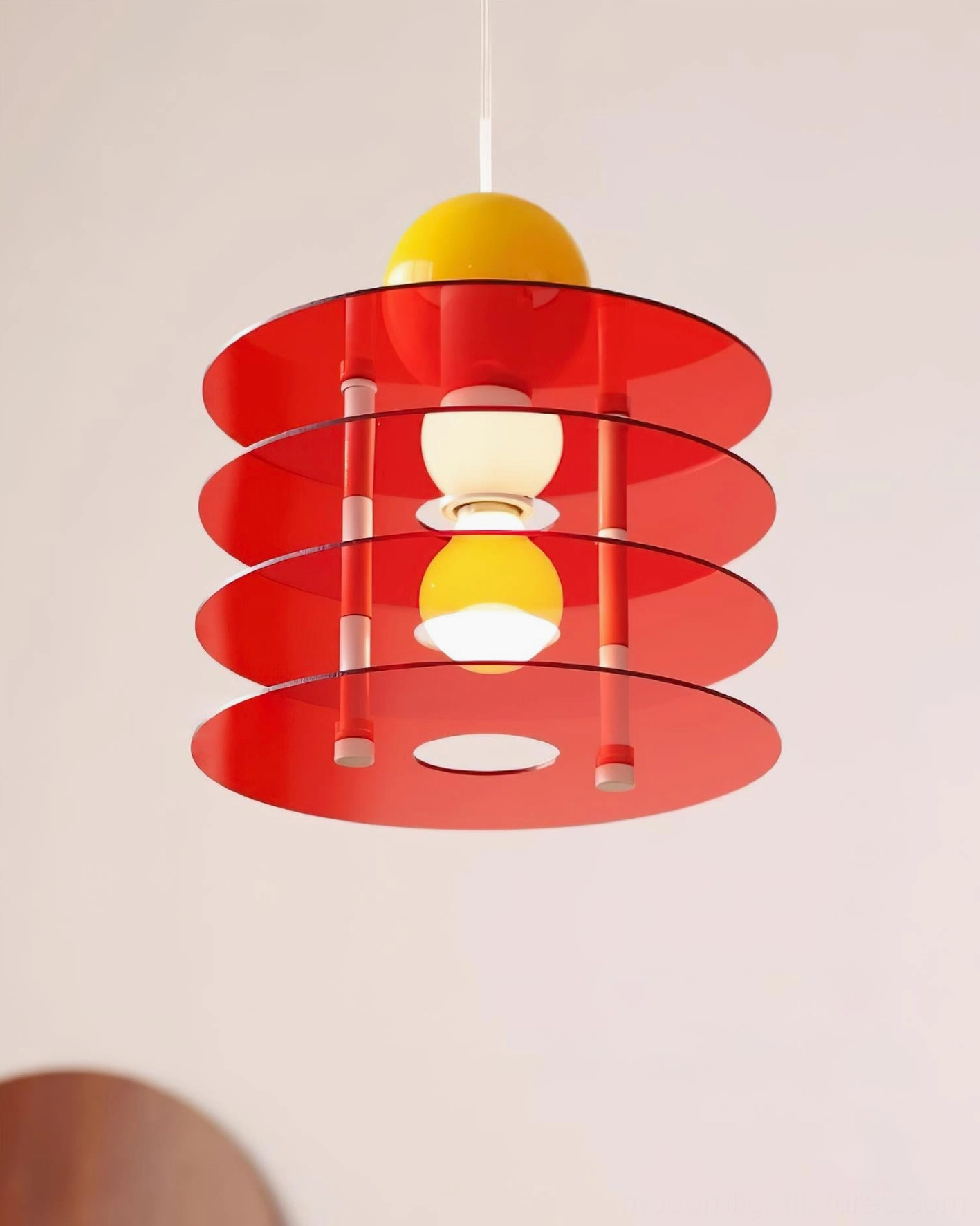 Bright red tiered acrylic pendant lamp with yellow sphere and exposed dual bulbs
