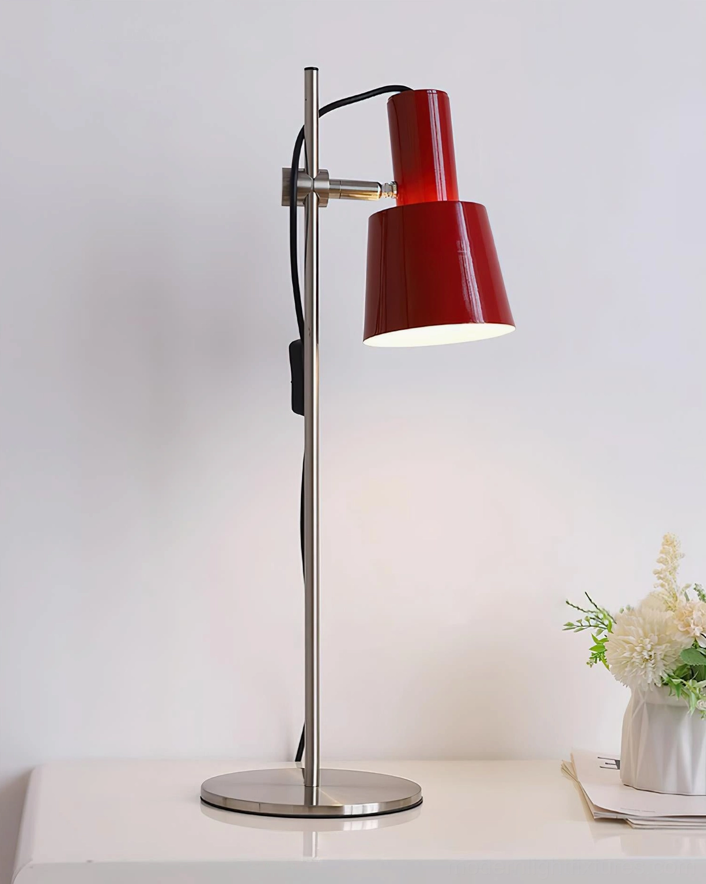 Contemporary dark red adjustable table lamp with polished silver metal stand on home side table with floral decor
