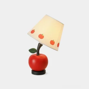 Apple-shaped red table lamp with fabric shade featuring fruit patterns, front studio view