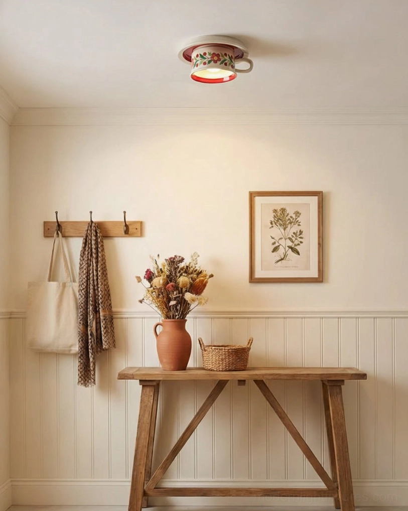 Red hand-painted ceramic tea cup ceiling light in small entryway with wainscoting walls and botanical wall art display