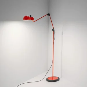 Red Paolo swing arm floor lamp positioned in corner of residential living space showing articulated positioning capability