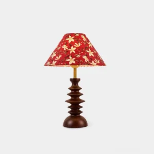 Red floral fabric shade table lamp with stacked walnut wood base and gold metal connector, front view studio