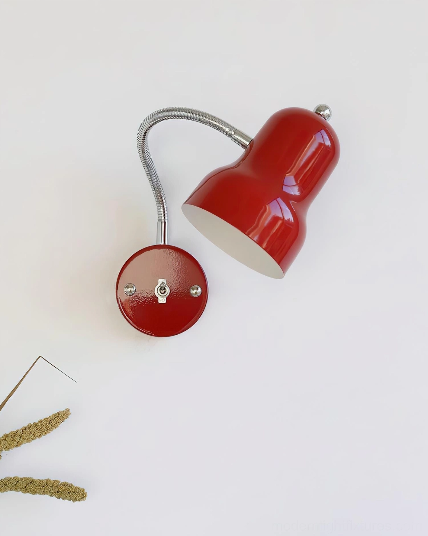 Red bell-shaped wall lamp with flexible metal gooseneck arm, three-quarter side profile