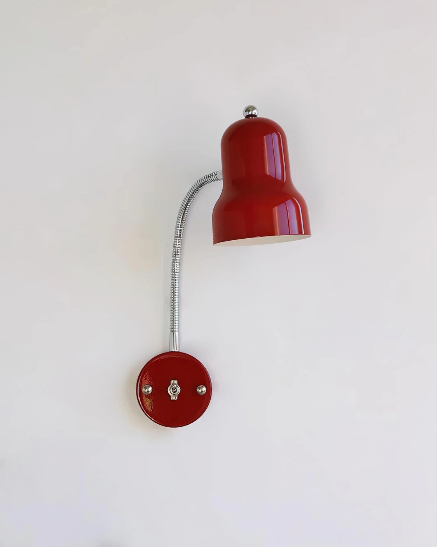 Red wall sconce with bell shade mounted and illuminated, retro industrial style design
