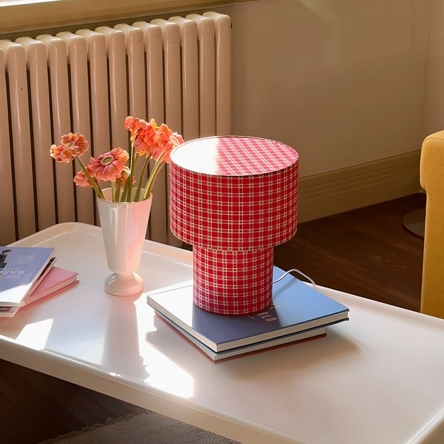 Red gingham latticefield lamp on stacked books coffee table with radiator and flower vase side view