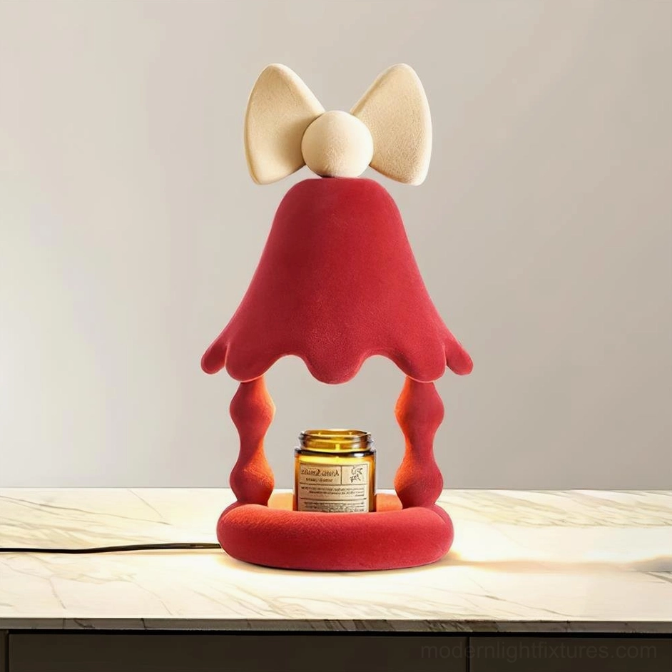 Red Stacy candle warmer table lamp on marble surface with visible power cord and branded scented candle jar, modern home setting