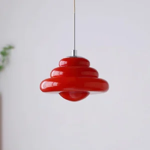 Crimson red modern tiered pendant lamp photographed at three-quarter angle with minimalist interior setting
