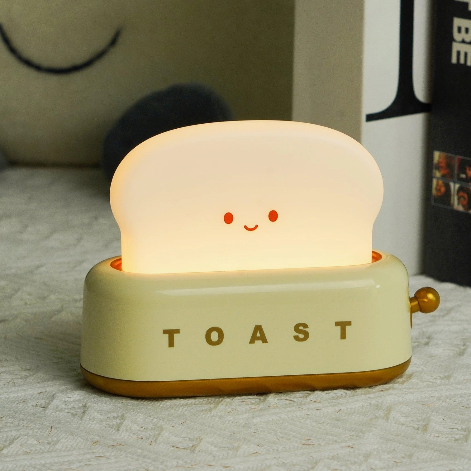 Red toaster table lamp with smiling face detail on bedroom bedside with cream and gold accents