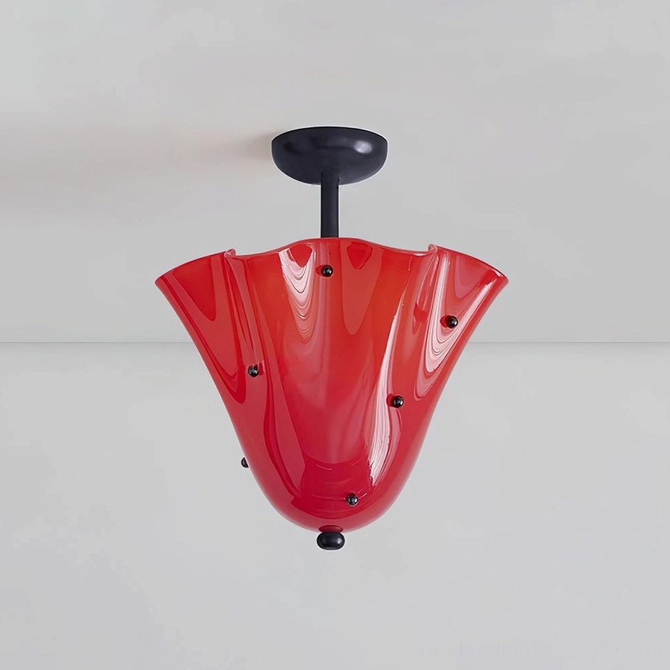 Red sculptural ceiling fixture with decorative studs and black canopy mounted on light gray wall