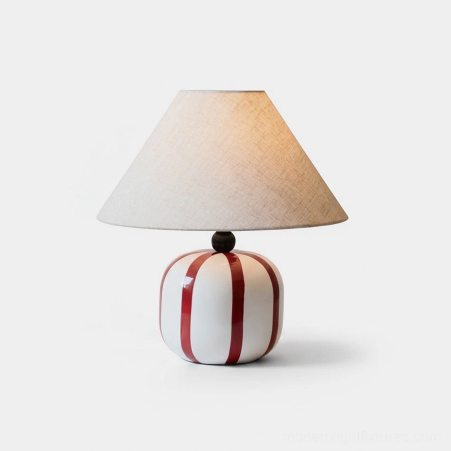 Red and white striped ceramic table lamp close-up front view on plain background
