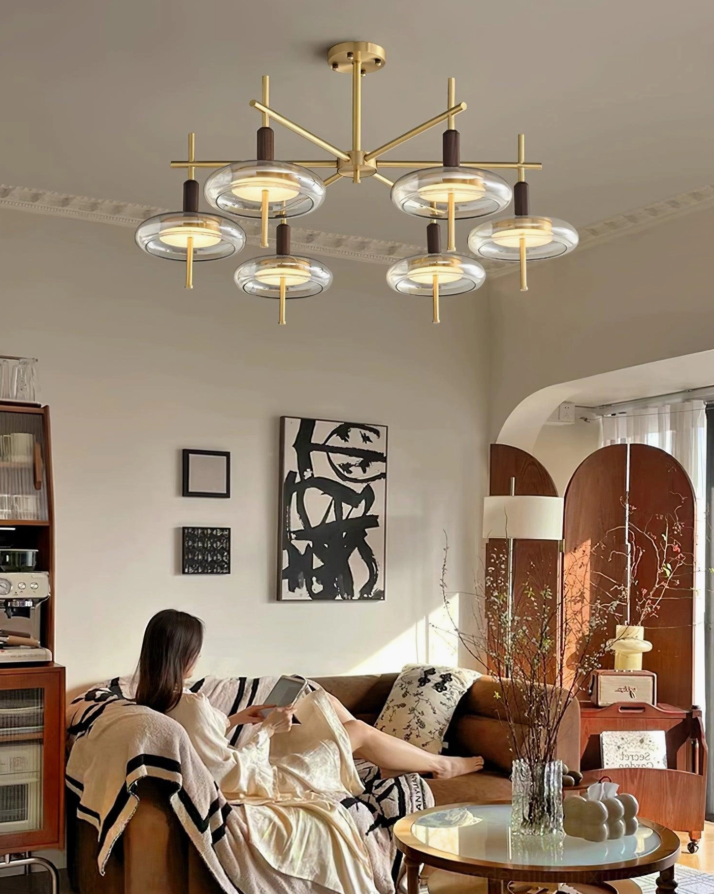 Redondo 8-head branch chandelier in warm vintage home lounge with brass gold frame and glass shades