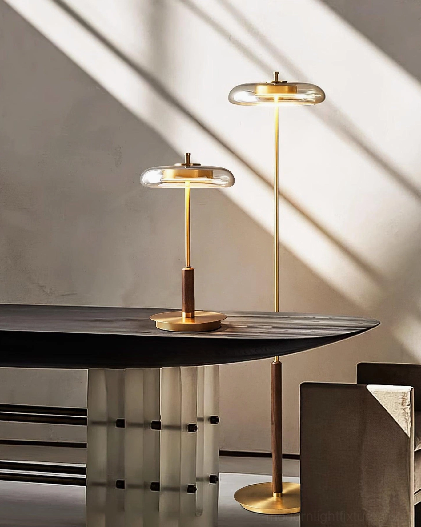 Pair of Redondo brass floor lamps and matching table lamp creating ambient dappled lighting in modern dining area
