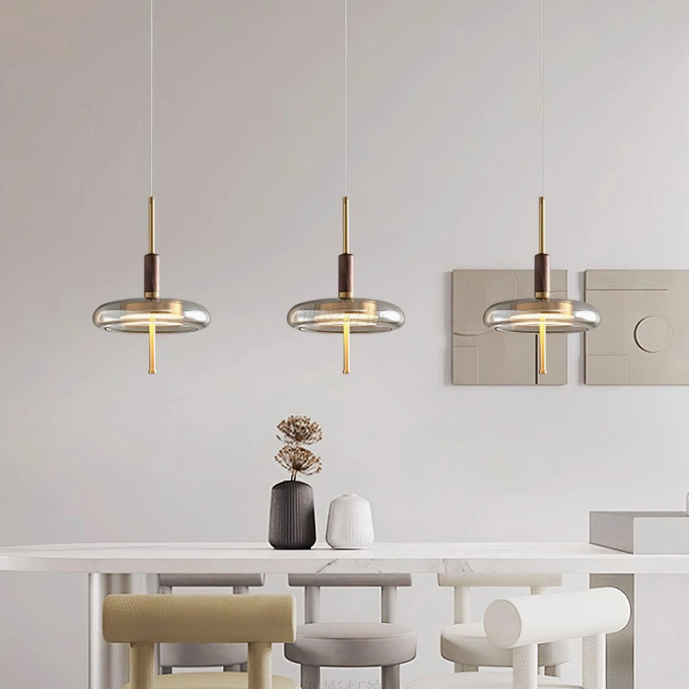 Redondo brass pendant detail close-up showing clear amber glass shade, polished brass base, and walnut accent