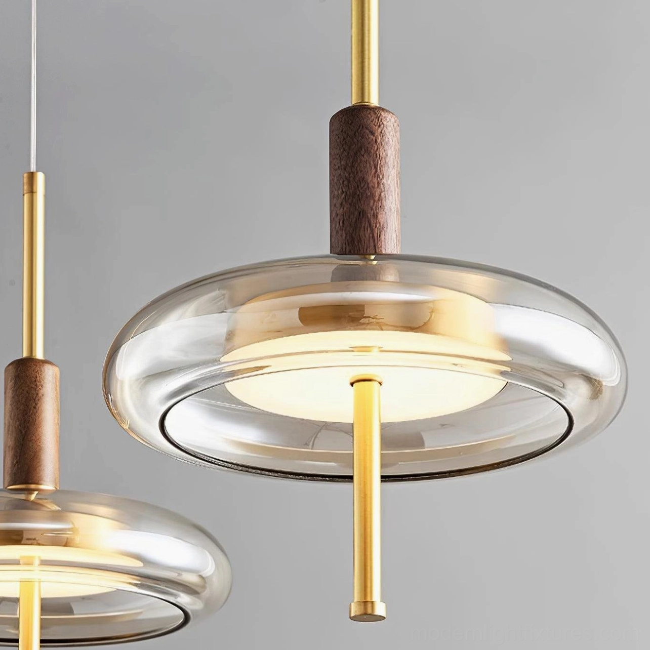 Dual Redondo disc pendant lamps flanking bed in warm modern master bedroom, symmetrical luxury lighting arrangement