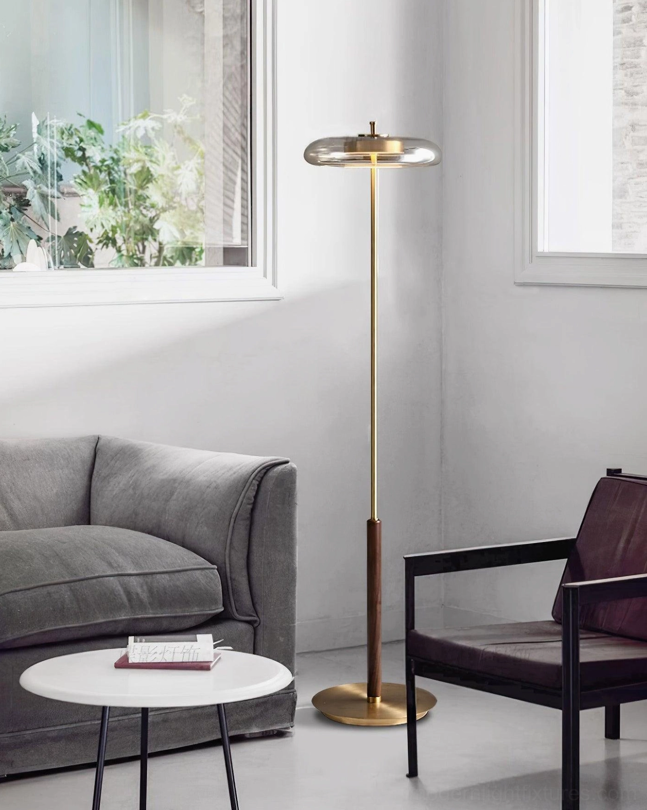 Detailed view of Redondo floor lamp brass base construction and geometric disc shade form in minimalist interior