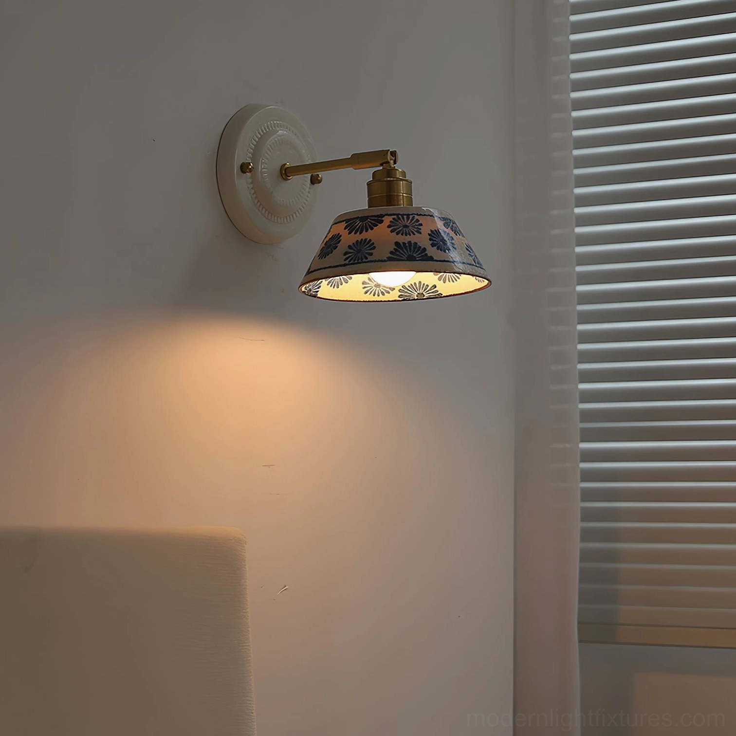 Hand-glazed indigo ceramic shade on wall sconce with refined brass hardware composition
