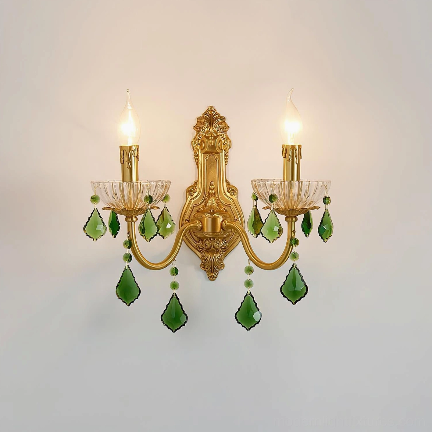 Front perspective of brass carved wall sconce with green crystal accents, studio background