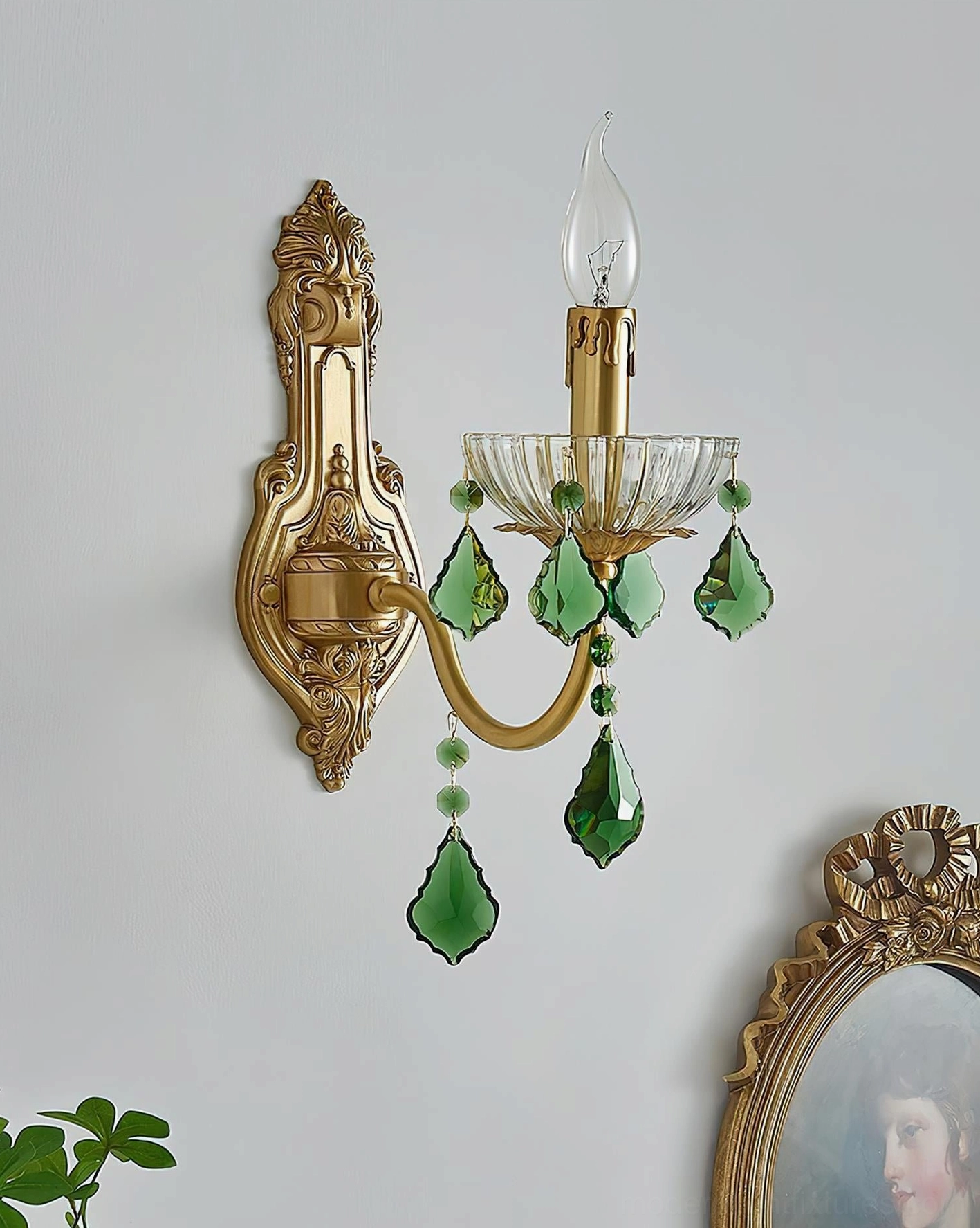 Side angle view of baroque brass wall sconce with green crystal decorative accents