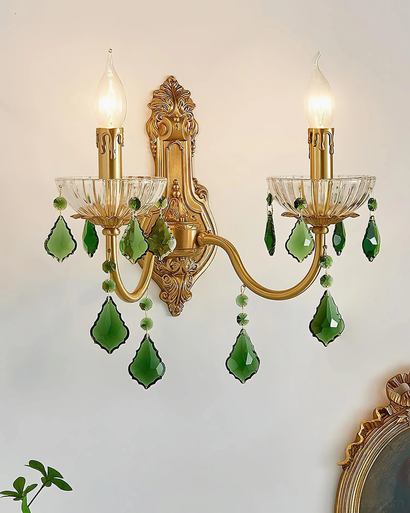 Illuminated dual candle crystal wall lamp with ornate carved frame on vintage wall decor