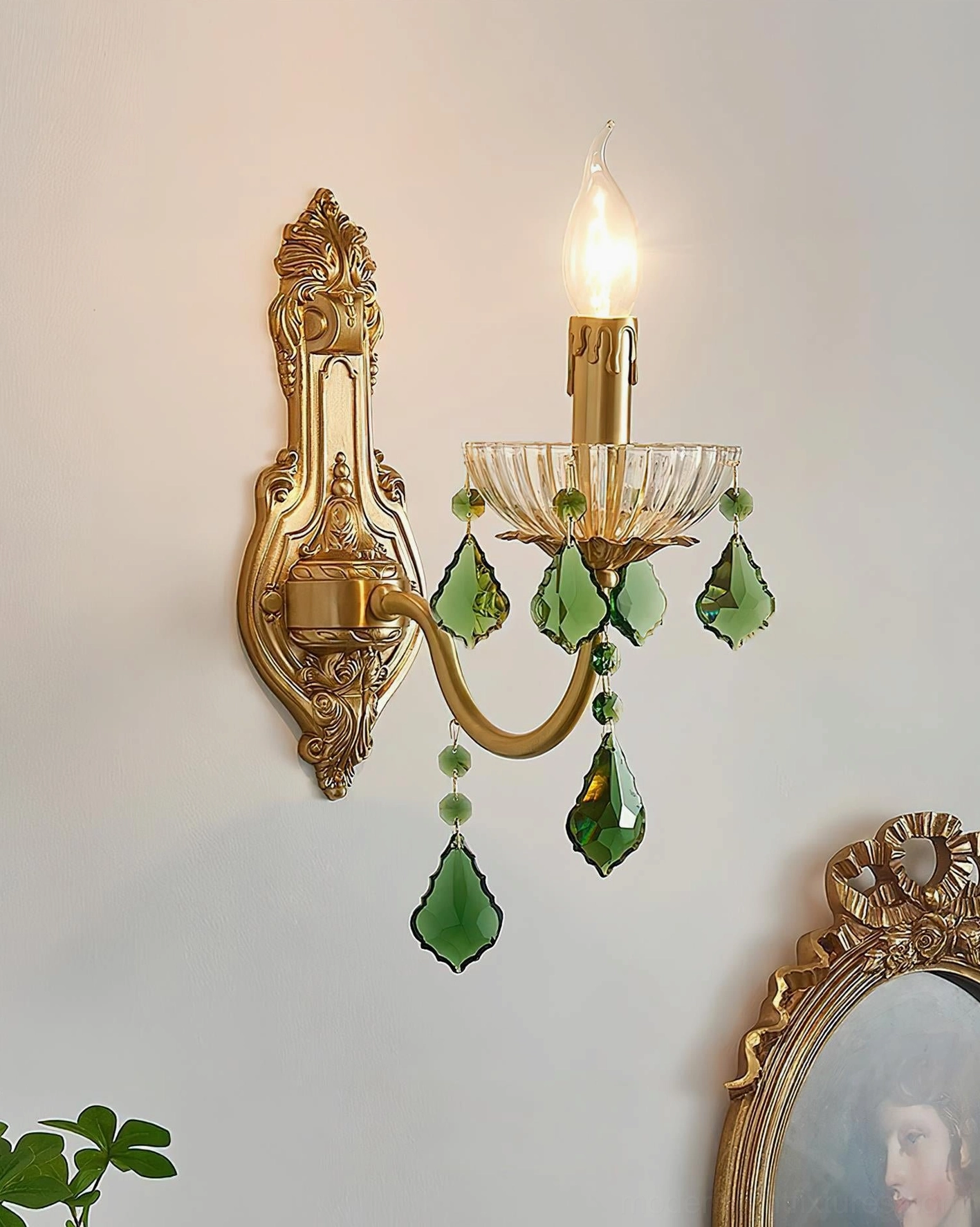 Lit single candle vintage wall lamp with ornate brass frame and emerald crystal details