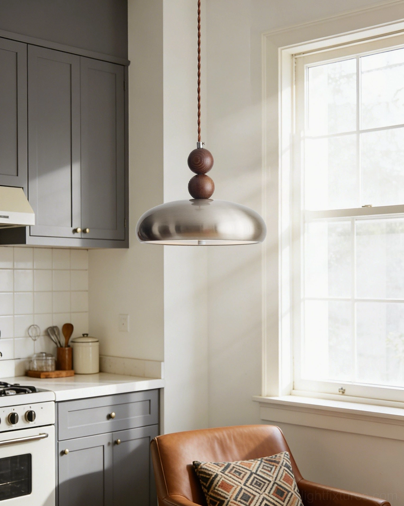 Rellin pendant lamp hanging in contemporary kitchen above dining area with grey cabinetry and warm neutral interior design