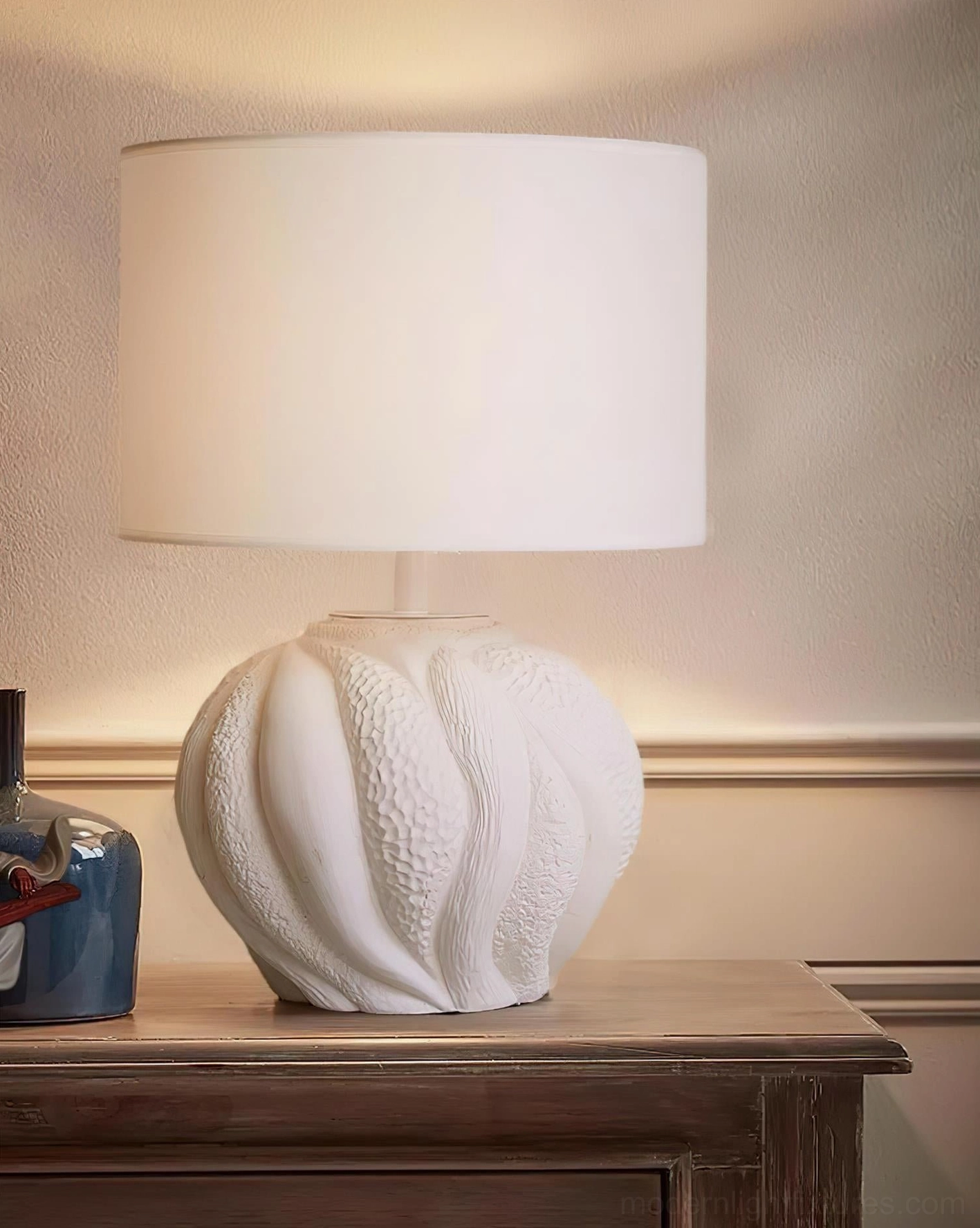 Remi table lamp on traditional wooden furniture with classic home decor accessories and blue decorative bottle