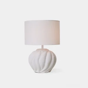 Remi white ceramic table lamp with fabric drum shade, front studio view showcasing textured ceramic base and warm diffused lighting