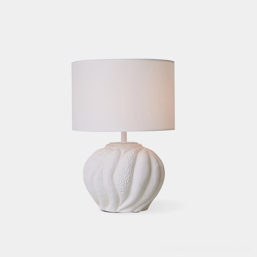 Remi white ceramic table lamp with fabric drum shade, front studio view showcasing textured ceramic base and warm diffused lighting
