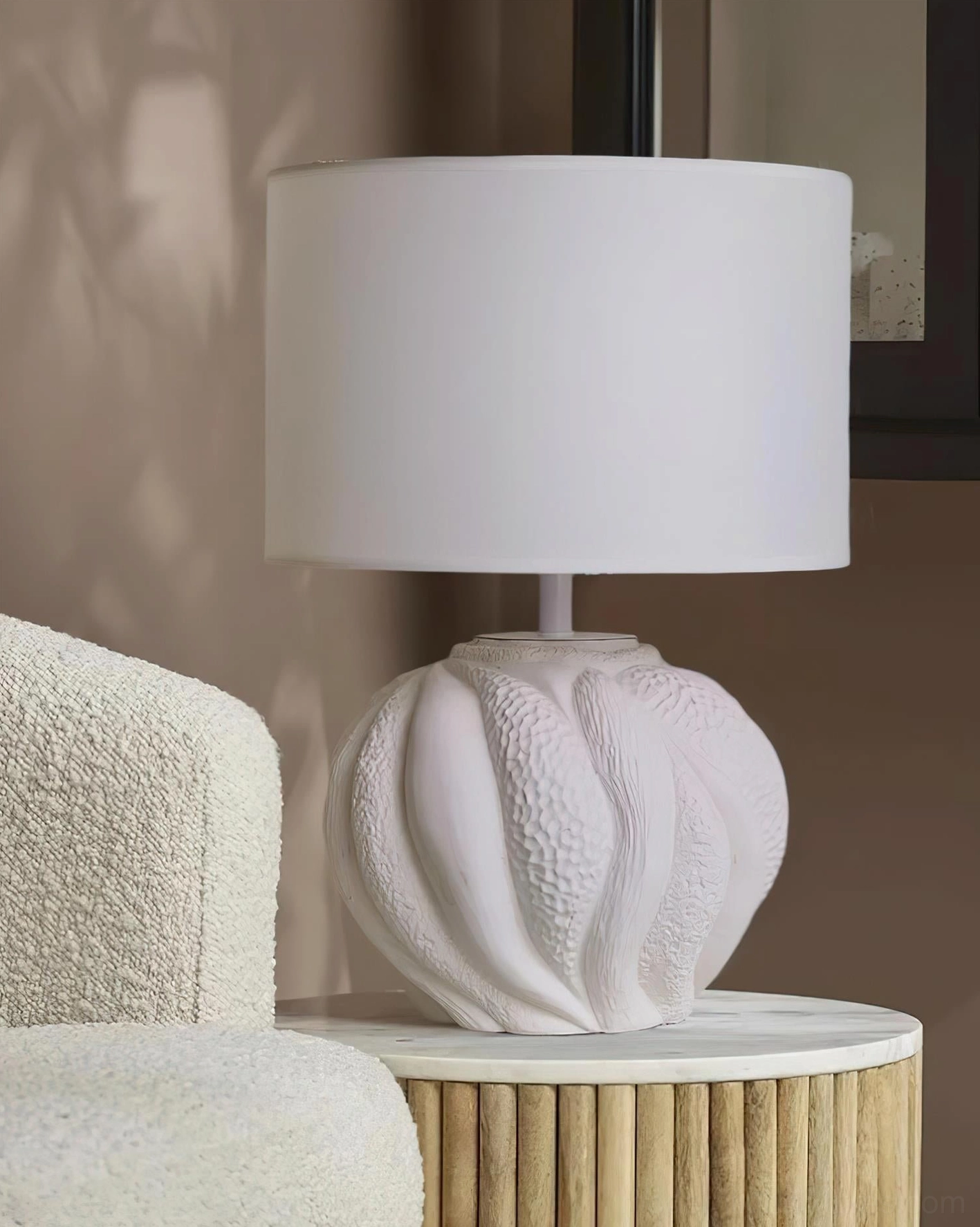 Remi white ceramic lamp on living room side table next to boucle upholstered sofa in modern minimalist setting