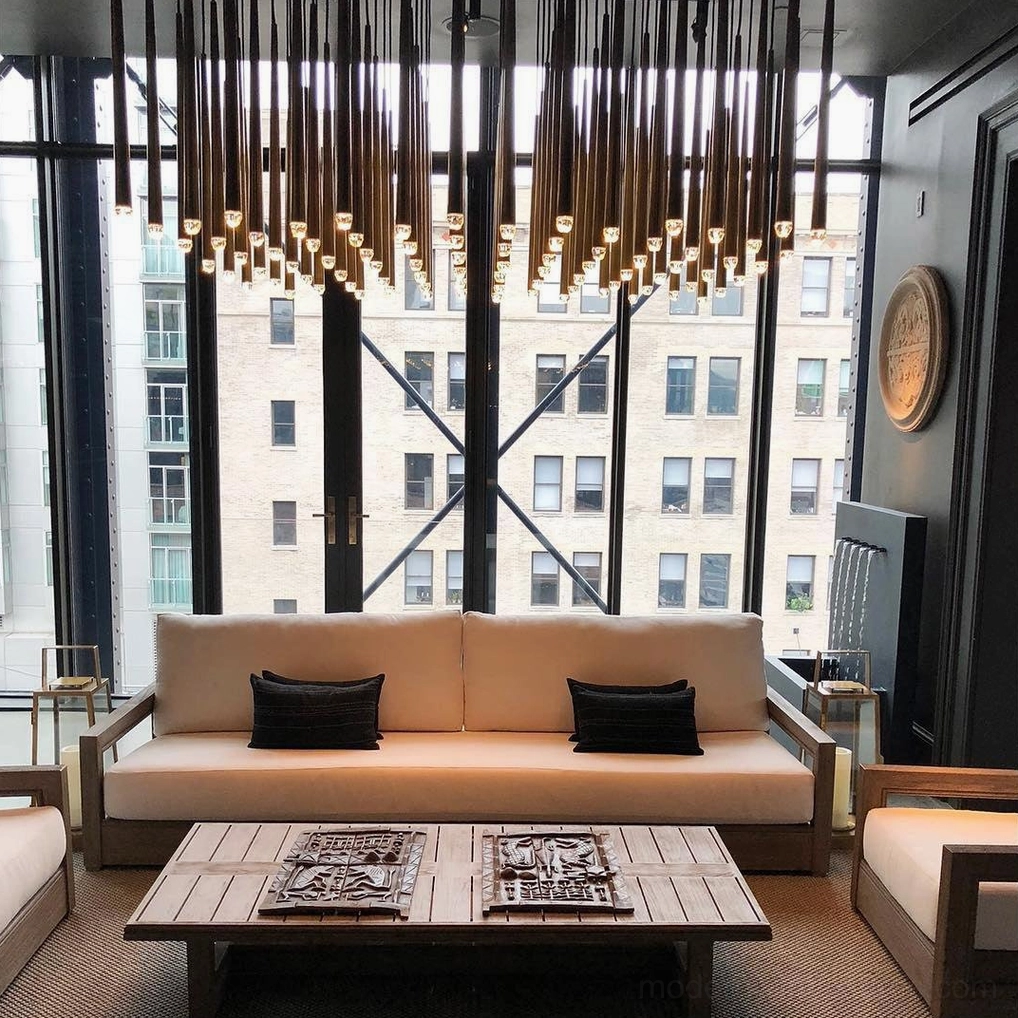 Renaie Large Linear Brass Chandelier in modern luxury living room with dark metallic finish