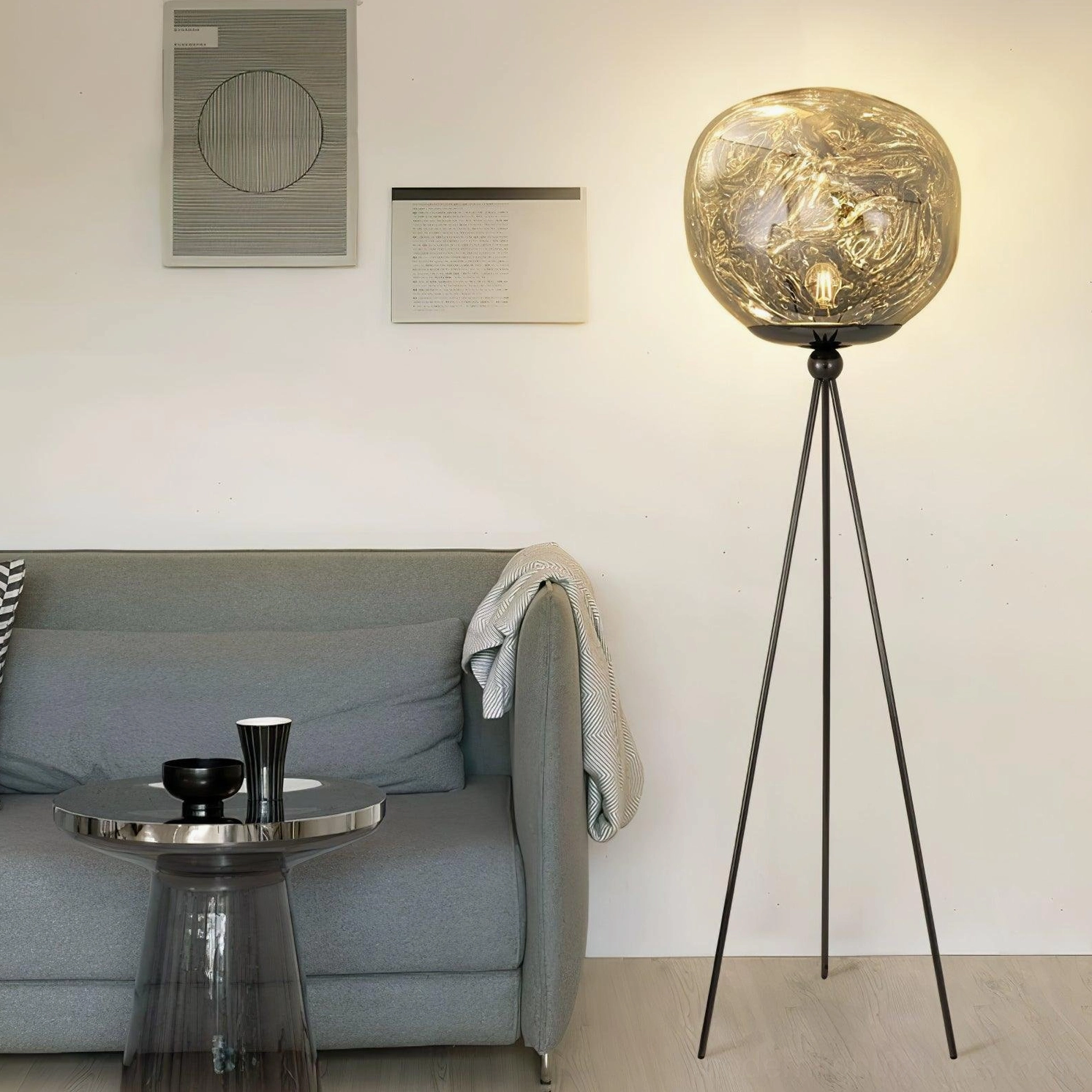 Modern tripod floor lamp with artistic molten glass shade in residential interior design setting